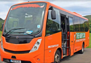 a passenger bus that is parked on the side of a road